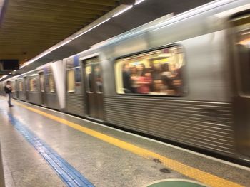 Blurred motion of train at illuminated railroad station