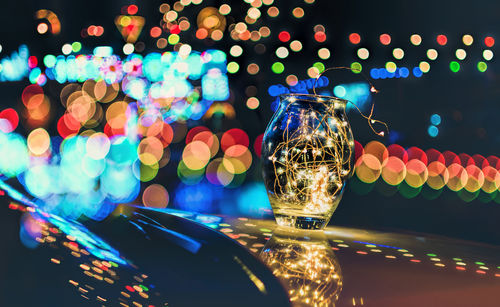 Close-up of illuminated candles on table