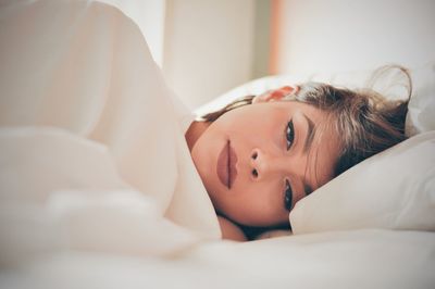 Close-up of woman lying on bed