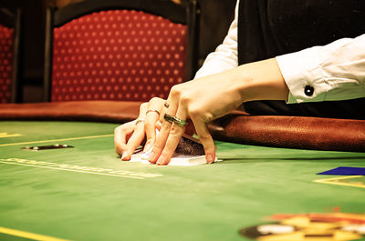 Midsection of woman playing poker on table