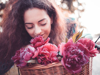 Close-up of woman with pink flowers in basket