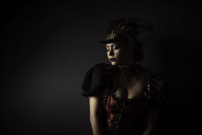 Woman in costume against black background