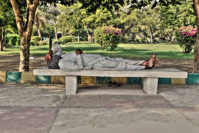 Woman sitting on bench in park