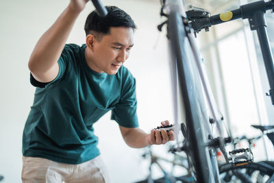 Side view of young man exercising at gym