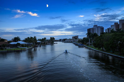 River amidst buildings in city against sky