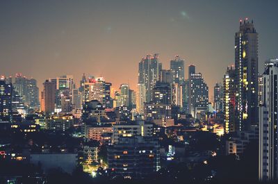 Illuminated cityscape against sky at night