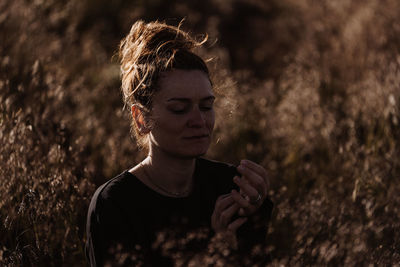 Portrait of young woman standing on field