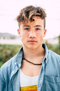 Portrait of young man wearing sunglasses against sky