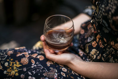 Midsection of woman holding alcohol glass