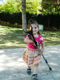 Portrait of cute girl playing with a crutch