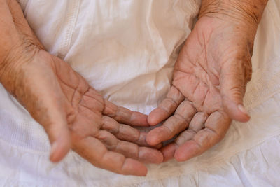 Close-up of woman hand on bed