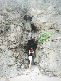 Woman standing at cave entrance
