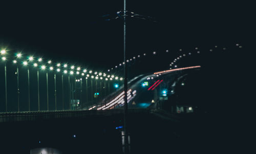 Illuminated bridge against sky at night