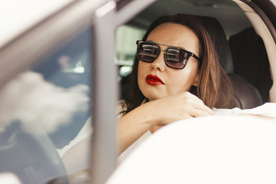 Woman wearing sunglasses in car