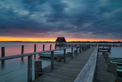 Pier over sea against sky during sunset