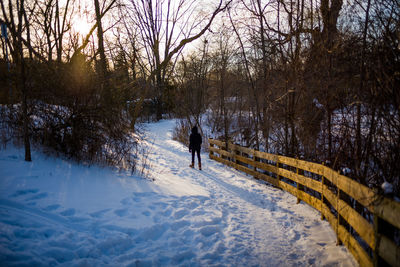 Woman walking on snow covered field