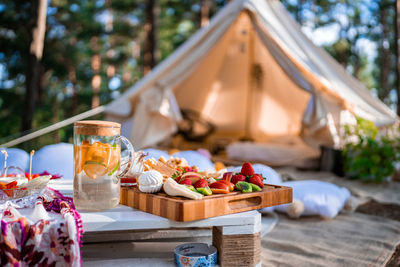 Picnic in the nature, table, carpets, wigwam, tent, pillows in the park.