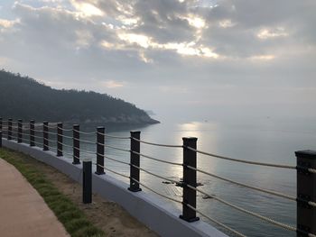 Scenic view of sea against cloudy sky during sunrise