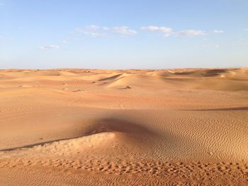 Sand dunes in desert against sky