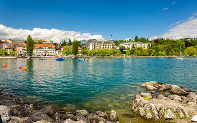 Scenic view of river by buildings against sky