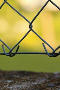 Close-up of raindrops on chainlink fence