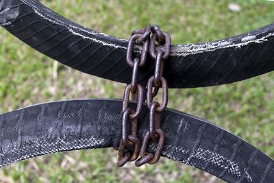 Close-up of chain hanging on metal fence