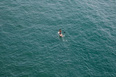 High angle view of man paddleboarding on sea