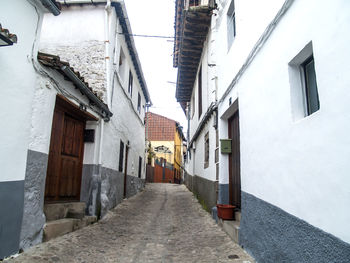 Street amidst houses against sky