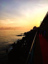 People walking on sea during sunset