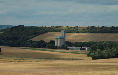 Scenic view of field against cloudy sky