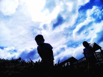 Low angle view of silhouette people at music concert against sky