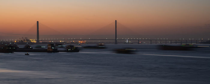 Bridge over river against sky during sunset