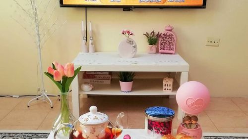 Flower vase on table against wall at home