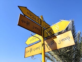 Low angle view of road sign against sky