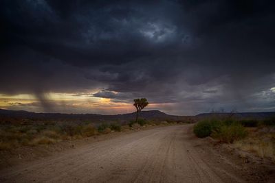 Country road against cloudy sky