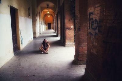 Woman sitting in corridor