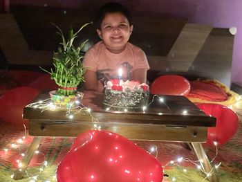 Portrait of happy man with candles on table
