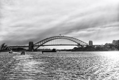 Bridge over river in city against sky