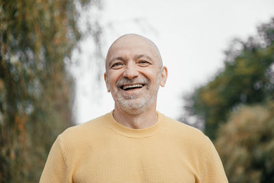 Relaxed senior man in yellow sweater enjoying the outdoors