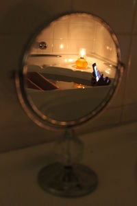 Reflection of man in illuminated mirror