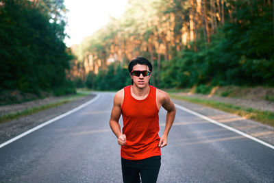 Portrait of young woman wearing sunglasses on road