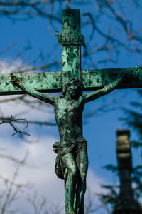 Low angle view of cross on tree against sky