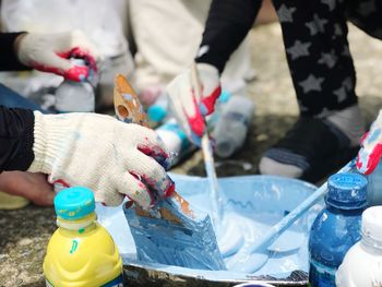 Midsection of people holding bottle