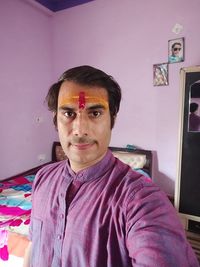 Portrait of young man standing at home
