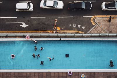 Directly above shot of people in swimming pool by street