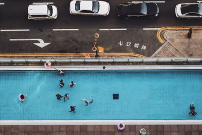 Directly above shot of people in swimming pool by street