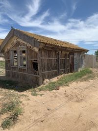 Old abandoned building on field against sky