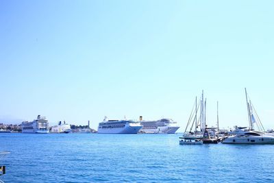 Boats sailing in sea against clear sky