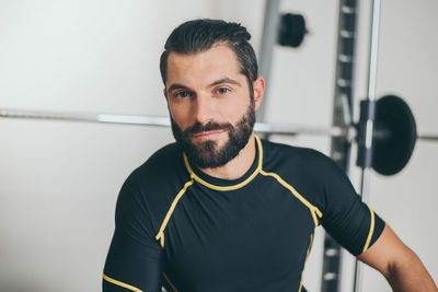 Portrait of beautiful sweaty man after training gym session. sporty boy after work out taking rest 