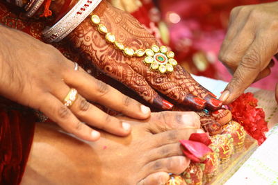 Close-up of person touching bride and groom feet